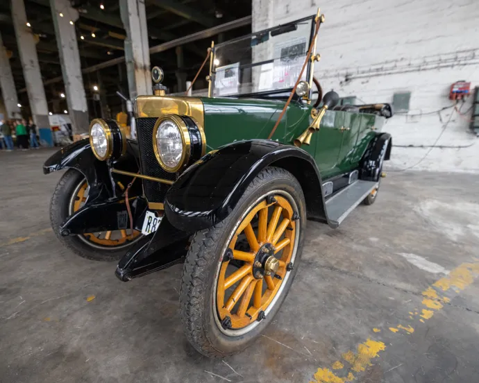 En grön och gul bil parkerad inne i en byggnad.