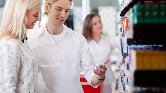 En tjej och en kille i bild som kollar på varor i ett Apotek