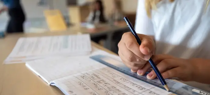 En person som skriver på ett papper med en penna.